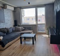 Living room with a sofa, black table, and wooden decor flooring.