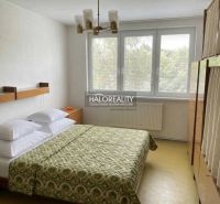 Bedroom with a bed and a cabinet in a light 3-room apartment, cream-colored walls.