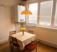A dining room with wooden decor, a radiator, and a window in a 3-room apartment.