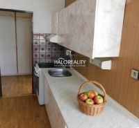 A kitchen in a 3-room apartment with a wooden decor floor and a basket of apples.