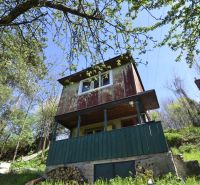 A cottage surrounded by greenery and trees in gardens around Zvolen.