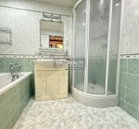 A bathroom in a 3-room apartment with a bathtub, shower, and washbasin cabinet.