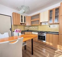 A kitchen in a 3-room apartment with a wood-patterned floor and a dining table.