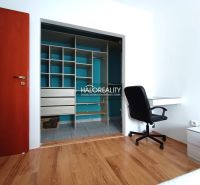 A room in a 2-room apartment with a wooden decor floor and a built-in wardrobe.