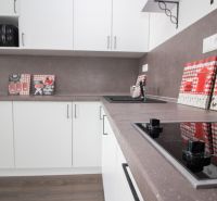White kitchen with a countertop in a studio apartment, floor with wood decor.