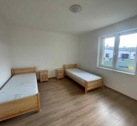 A room with two single beds, nightstands, and a floor with a wooden decor.
