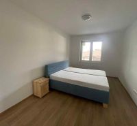 A bedroom in a family house with a bed and a wooden decor floor.