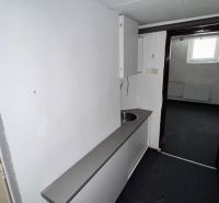 A narrow corridor with a kitchenette in commercial premises.