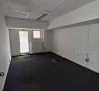 Commercial premises with dark flooring and glass doors, with white walls.