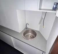 Kitchen corner with sink and shelves in commercial premises.