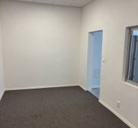 Offices with white walls and gray carpet, visible entrance doors.