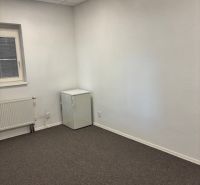 Offices with a window, radiator, and white wall, carpet.