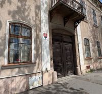 Unique properties in Komárno with historic wooden doors and windows with bars.