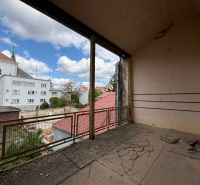 Unusual properties in Komárno with a damaged wall and a view of the city architecture.