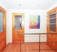 A hallway with wooden doors and a floor with a wooden decor in a family house.
