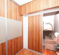 Built-in wardrobe with sliding doors and a wooden decor floor in a family house.