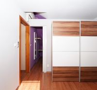 Wardrobe with sliding doors, floor with wood decor, purple wall, air conditioning.