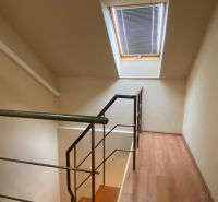 A staircase in a family house with a wooden decor floor and a skylight.