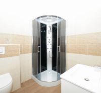 A bathroom with a corner shower and tiles with a light decor in a family house.