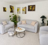 Living room in a family house with armchairs, a fireplace, and art paintings on the wall.