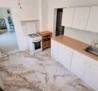 A kitchen in a family house with white cabinets and a gas stove.