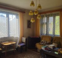 Living room in a family house with retro chandeliers and large windows with curtains.