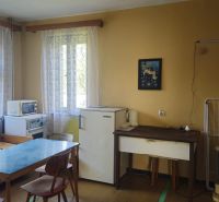 A kitchen in a family house with simple furniture, a table, and appliances.
