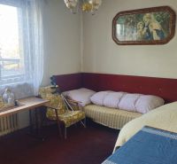 A room in a family house with retro furniture, decoration, and a view from the window.
