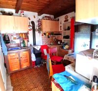 A kitchen with wooden decor, cabinets, and kitchen utensils on the wall in the Gardens.