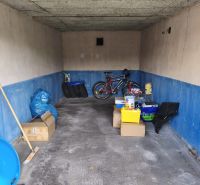A garage in Prievidza on Dlhá Street with stored boxes and a bicycle.