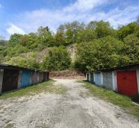 Parking garages on Dlhá Street in Prievidza surrounded by natural forests and the sky.