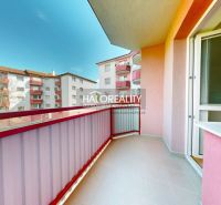 A balcony in a studio apartment, view of apartment buildings in Lučenec on a sunny day.