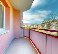A studio apartment balcony with a view in the city of Lučenec, with pink walls and railing.