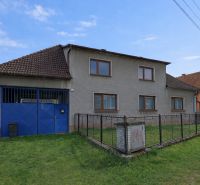 A family house in Horná Súča with a garage and a fenced lawn on a quiet street.