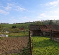 Older buildings and fields surrounded by nature in Horná Súča near the family house.