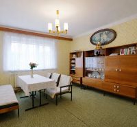 Living room in a family house with retro furniture, colorful walls, and a synthetic carpet.
