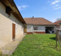The yard of a family house in Horná Súča with a grassy area and farm buildings.