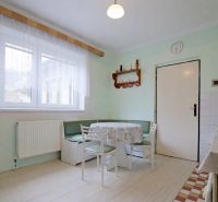 A kitchen in a family house with a corner bench, a white table, and chairs.