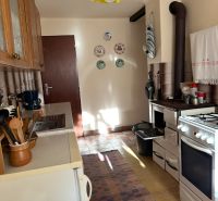 A kitchen in the Gardens with a yellow light fixture, an oven, and decorative plates on the wall.