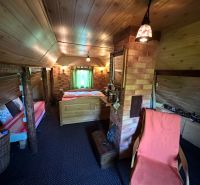 Attic room with a sofa, wooden ceiling, and brick wall in the Garden area.