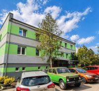 A building with a green-gray facade, parked cars on Cementár Street, Turňa nad Bodvou.