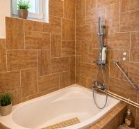 A bathroom with a built-in bathtub and decorative tiles in a 4-room apartment.