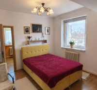 A bedroom in a 4-room apartment with a wooden decor floor and a prominent bed headboard.