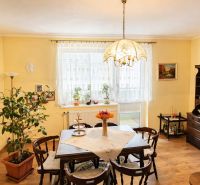 Traditional dining room in a 4-room apartment with wood-patterned flooring and decorations.