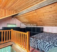 Attic room with wooden decor flooring, a bed, and railing in the attic of the garden.