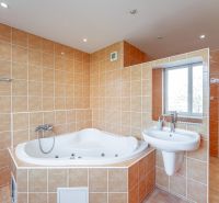 Bathroom in a 2-room apartment with a whirlpool bathtub, sink, and window.