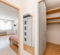 Interior of a 2-room apartment with a wooden decor floor, furniture, and a wardrobe.