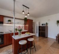 A kitchen in a 2-room apartment with a wooden decor countertop and floor.