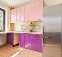 A kitchen in a family house with a colorful cabinet, a stainless steel refrigerator, and a floor with a wooden decor.