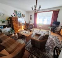 Living room in a family house with a sofa set, carpet, and wooden decor.